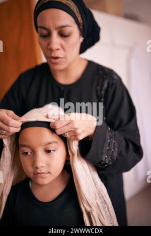 Mère, fille et musulmane avec aide, foulard et soutien pour la célébration et la culture de l'eid. Famille islamique, enfant et lien ensemble pour l'amour, la croissance Banque D'Images