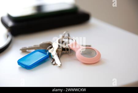 Gros plan des clés avec un AirTag pomme sur la table blanche Banque D'Images