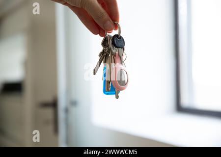 Gros plan de mains tenant des clés avec un AirTag Apple Banque D'Images