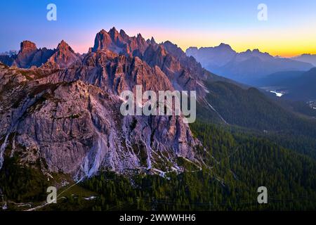 Vue aérienne de haute altitude des sommets des Dolomites éclairés par la lumière rose du ciel du coucher du soleil, avec la vallée du Lago di Misurina et le panorama des Dolomites. Banque D'Images