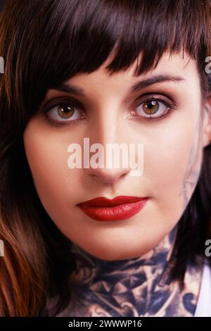 Portrait, tatouage et visage de femme gothique en studio pour style edgy ou rebelle dans un gros plan pour rouge à lèvres rouge. Maquillage, modèle punk unique ou cool avec de l'encre Banque D'Images