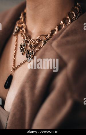 Chaîne dorée accrochée au cou d'une femme. Beaux accessoires de bijoux de luxe élégants Banque D'Images