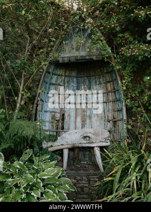 Un vieux bateau à rames en bois réutilisé utilisé comme ornement de jardin dans le Applecross Walled Garden à Applecross, Wester Ross, Highland Écosse Royaume-Uni Banque D'Images