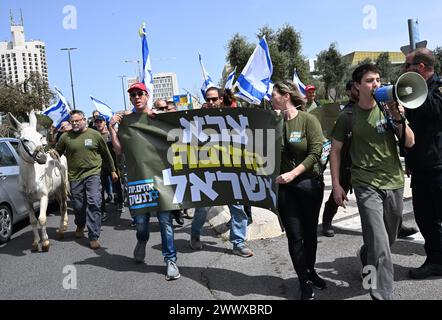 Jérusalem, Israël. 26 mars 2024. Des militants de réserve de l'armée israélienne de Brother in Arms marchent avec un âne lors d'une manifestation contre l'exemption militaire pour l'ultra-orthodoxe Haredim devant le bureau du premier ministre Benjamin Netanyahu à Jérusalem le mardi 26 mars 2024. Les manifestants réclament l'égalité dans le service militaire israélien avec le slogan "nous ne continuerons pas d'être votre âne" faisant référence au service militaire obligatoire pour tous les Israéliens, à l'exception des Juifs religieux ultra-orthodoxes. Photo de Debbie Hill/ crédit : UPI/Alamy Live News Banque D'Images