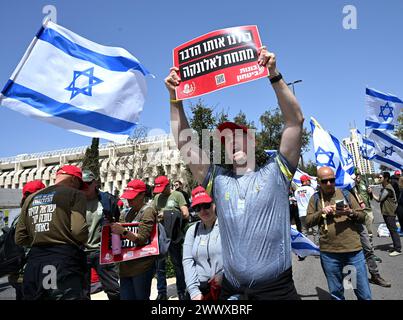 Jérusalem, Israël. 26 mars 2024. Des militants de réserve de l'armée israélienne de Brother in Arms brandissent des drapeaux israéliens lors d'une manifestation contre l'exemption militaire pour l'ultra-orthodoxe Haredim devant le bureau du premier ministre Benjamin Netanyahu à Jérusalem le mardi 26 mars 2024. Les manifestants réclament l'égalité dans le service militaire israélien avec le slogan "nous ne continuerons pas d'être votre âne" faisant référence au service militaire obligatoire pour tous les Israéliens, à l'exception des Juifs religieux ultra-orthodoxes. Photo de Debbie Hill/ crédit : UPI/Alamy Live News Banque D'Images