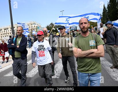 Jérusalem, Israël. 26 mars 2024. Des militants de réserve de l'armée israélienne de Brother in Arms brandissent des drapeaux israéliens lors d'une manifestation contre l'exemption militaire pour l'ultra-orthodoxe Haredim devant le bureau du premier ministre Benjamin Netanyahu à Jérusalem le mardi 26 mars 2024. Les manifestants réclament l'égalité dans le service militaire israélien avec le slogan "nous ne continuerons pas d'être votre âne" faisant référence au service militaire obligatoire pour tous les Israéliens, à l'exception des Juifs religieux ultra-orthodoxes. Photo de Debbie Hill/ crédit : UPI/Alamy Live News Banque D'Images