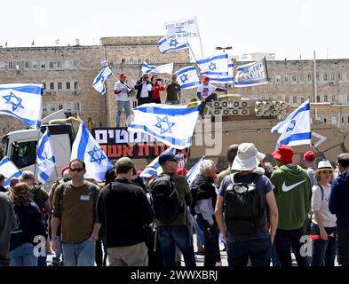 Jérusalem, Israël. 26 mars 2024. Des militants de réserve de l'armée israélienne de Brother in Arms brandissent des drapeaux israéliens lors d'une manifestation contre l'exemption militaire pour l'ultra-orthodoxe Haredim devant le bureau du premier ministre Benjamin Netanyahu à Jérusalem le mardi 26 mars 2024. Les manifestants réclament l'égalité dans le service militaire israélien avec le slogan "nous ne continuerons pas d'être votre âne" faisant référence au service militaire obligatoire pour tous les Israéliens, à l'exception des Juifs religieux ultra-orthodoxes. Photo de Debbie Hill/ crédit : UPI/Alamy Live News Banque D'Images