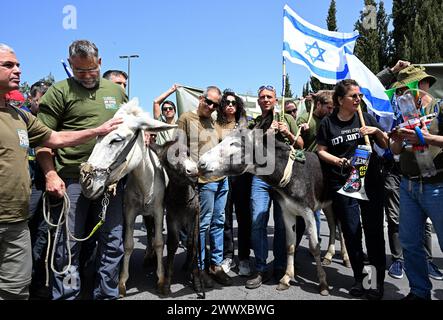 Jérusalem, Israël. 26 mars 2024. Des militants de réserve de l'armée israélienne de Brother in Arms se tiennent avec des ânes lors d'une manifestation contre l'exemption militaire pour l'ultra-orthodoxe, Haredim, devant le bureau du premier ministre Benjamin Netanyahu à Jérusalem le mardi 26 mars 2024. Les manifestants réclament l'égalité dans le service militaire israélien avec le slogan "nous ne continuerons pas d'être votre âne" faisant référence au service militaire obligatoire pour tous les Israéliens, à l'exception des Juifs religieux ultra-orthodoxes. Photo de Debbie Hill/ crédit : UPI/Alamy Live News Banque D'Images