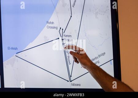 26 mars 2024, Israël, Kerem Schalom : un représentant de l'unité COGAT du ministère israélien de la Défense montre une carte lors d'une visite du ministre des Affaires étrangères Baerbock au poste frontière de Kerem Shalom dans la bande de Gaza du côté israélien. Les secours sont acheminés vers la bande de Gaza par camion depuis le poste frontière situé dans la zone frontalière entre l'Égypte, Israël et la bande de Gaza. Le ministre des Affaires étrangères Baerbock se rend en Israël pour la sixième fois depuis l’attaque du Hamas contre Israël le 7 octobre pour discuter à nouveau de la situation à Gaza et en Israël. Photo : Christoph Soeder/dpa-Pool/dpa Banque D'Images