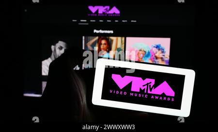 Personne tenant le téléphone portable avec le logo du prix show MTV Video Music Awards (VMA) en face de la page Web de l'entreprise. Concentrez-vous sur l'affichage du téléphone. Banque D'Images