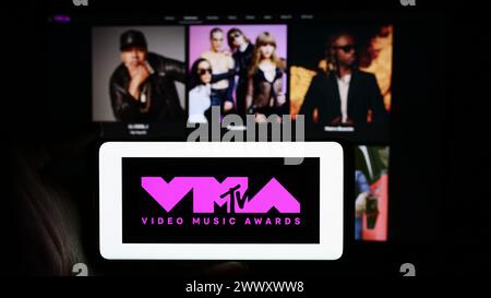 Personne tenant le téléphone portable avec le logo de l'émission de prix MTV Video Music Awards (VMA) en face de la page Web de l'entreprise. Concentrez-vous sur l'affichage du téléphone. Banque D'Images