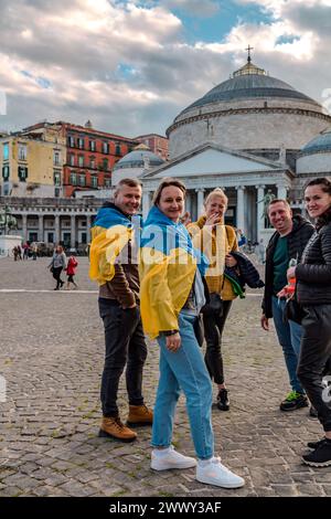 Naples, Italie - 10 avril 2022 : des civils soutenant l'Ukraine dans le conflit de 2022 avec la Russie, attachant des drapeaux nationaux ukrainiens à Naples, Banque D'Images