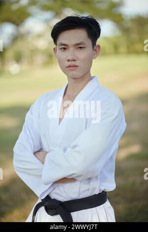 Portrait d'athlète de taekwondo sérieux et confiant portant dobok avec ceinture noire Banque D'Images