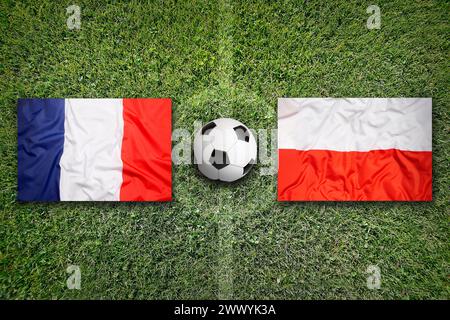 France vs Pologne drapeaux sur un terrain de football vert Banque D'Images