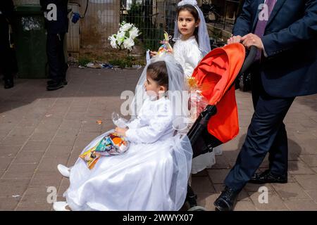 Deux jeunes filles habillées en reine Esther sont vues pendant les célébrations de Pourim. Les Juifs ultra-orthodoxes célèbrent Pourim à Bnei Brak, en Israël. La fête commémore le salut des Juifs dans l'ancienne Perse d'un complot pour les anéantir. Une fête joyeuse, elle est célébrée par les juifs laïcs et non laïcs, notamment en déguisant des costumes et en buvant, selon le Talmud, ìuntil il ne peut pas distinguer entre ëcursed is Hamaní et ëblessed is Mordechai.íî les juifs ultra-orthodoxes célèbrent Pourim à Bnei Brak, en Israël. La fête commémore le salut des Juifs dans l'ancienne Perse Banque D'Images