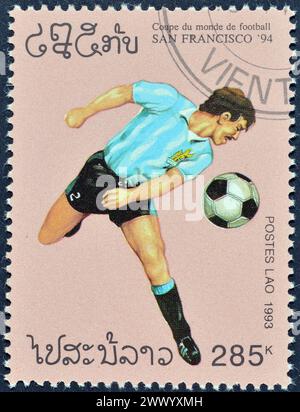 Timbre-poste annulé imprimé par le Laos, qui promeut le championnat de la Coupe du monde de football de la FIFA 1994, États-Unis, vers 1993. Banque D'Images