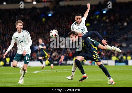 L'écossais Nathan Patterson (au centre) se bat pour le ballon contre l'irlandais Isaac Price (à gauche) et Brodie Spencer lors d'un match amical international à Hampden Park, Glasgow. Date de la photo : mardi 26 mars 2024. Banque D'Images