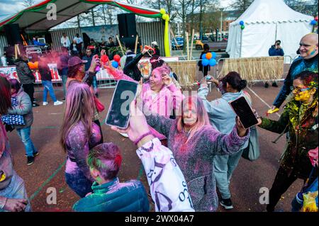 Un groupe de femmes vues danser en jetant de la poudre rose. Des millions de personnes dans le monde entier célèbrent le festival annuel Holi Hangámá, également connu sous le nom de Festival des couleurs, qui signifie célébrer l'arrivée du printemps. À la Haye, où se trouve la plus grande population indienne en Europe, une grande célébration a eu lieu dans le quartier multiculturel du Transvaal, où les participants ont jeté de la poudre aux couleurs vives sur eux-mêmes et les uns sur les autres. Les gens ont célébré cet événement en se promenant dans le quartier en chantant et en dansant dans une procession colorée. Banque D'Images