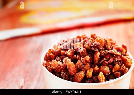 Bouquet de raisins secs dans un bol sur une table en bois, fruits de raisin séchés mangeant crus ou utilisés en cuisine Banque D'Images