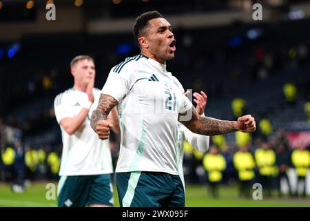 Josh Magennis d'Irlande du Nord (au centre) célèbre après le coup de sifflet final dans un match amical international à Hampden Park, Glasgow. Date de la photo : mardi 26 mars 2024. Banque D'Images