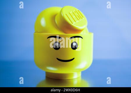 Boîte jaune Lego Head avec fond gris. Banque D'Images