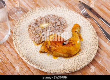 Sarrasin bouilli dans un bol avec cuisses de poulet. Table de dîner, concept de nourriture saine Banque D'Images