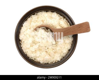 flocons de riz aplatis dans un bol en céramique isolé sur blanc. Banque D'Images