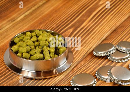 Granulés de houblon pour le brassage de la bière. Ingrédients de brassage maison et bouchons de bouteille de bière. Banque D'Images