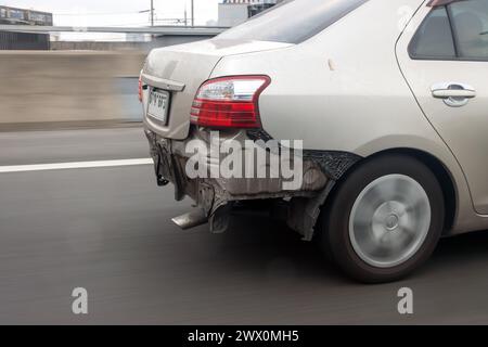 Une voiture roule sur la route sans pare-chocs arrière Banque D'Images