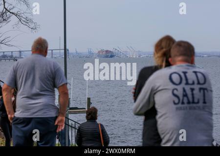 Les spectateurs voient les efforts de sauvetage des autorités, alors qu'ils recherchent des personnes piégées sous les restes du pont Francis Scott Key à l'extérieur de Baltimore, Maryland, après qu'un porte-conteneurs a perdu du courant et a heurté le pont tôt le matin le mardi 26 mars 2024. Crédit : Aaron Schwartz/CNP Banque D'Images