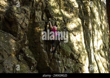 Femme escalade au Sully's Hangout dans Lynn Canyon, North Vancouver, Canada Banque D'Images