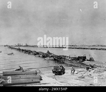 Légende originale : « ces plates-formes d'atterrissage improvisées, s'étendant dans le chenal depuis Omaha Beach, en France, seront utilisées pour recevoir de grandes quantités de matériel provenant d'embarcations de débarquement pour le transfert vers le continent. » env. 23 juin 1944 Banque D'Images