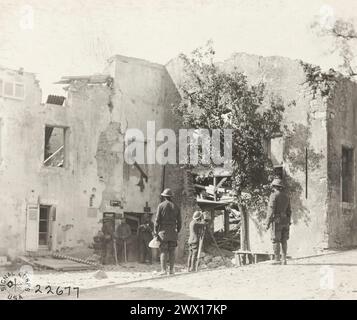 Photos de la première Guerre mondiale : (légende originale) Un film d'homme de film sur un prisonnier de guerre allemand entrant en ville avec un garde, montrant également la destruction de la ville par des tirs d'artillerie ; Vilsey-sur-Trey, France CA. 1918 Banque D'Images