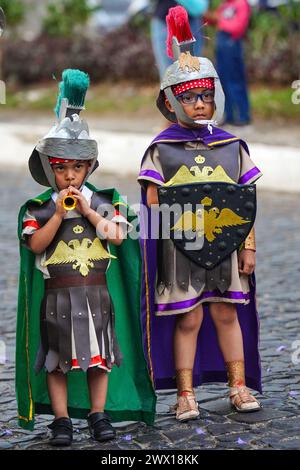 Antigua, Guatemala. 26 mars 2024. De jeunes garçons guatémaltèques habillés en centurions romains défilent avant la procession de Jésus de Nazareth le mardi Saint pendant Semana Santa, le 26 mars 2024 à Antigua, Guatemala. Les processions opulentes, les algèbres détaillées et les traditions séculaires attirent plus d'un million de personnes dans l'ancienne capitale. Crédit : Richard Ellis/Richard Ellis/Alamy Live News Banque D'Images