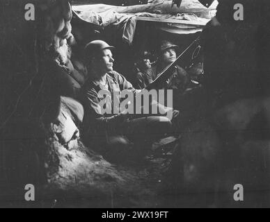 Les fantassins du 27th Infantry Regiment, près de Heartbreak Ridge, profitent de la couverture et de la dissimulation dans les positions de tunnel, à 40 mètres des communistes CA. Août 1952 Banque D'Images