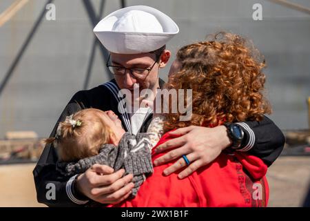 Norfolk, Virginie, États-Unis. 21 mars 2024. Technicien en électronique de 3e classe Brennon Potter, affecté au navire d'assaut amphibie de classe Wasp USS Bataan (LHD 5), qui fait partie du Bataan Amphibious Ready Group (ARG), salue sa famille alors que Bataan retourne à la base navale de Norfolk après un déploiement de huit mois et demi opérant dans les zones d'opérations de la 5e et de la 6e flotte américaine, le 21 mars 2024. Plus de 4 000 marins et Marchines affectés à l'ARG de Bataan ont soutenu un large éventail d'opportunités et d'exercices d'interopérabilité, augmentant la préparation au combat et les capacités de réponse aux crises wh Banque D'Images