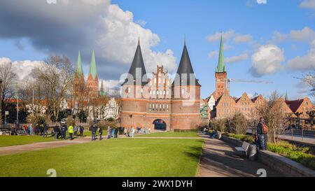 26 mars 2024, Schleswig-Holstein, Lübeck : vue sur Holstentorplatz jusqu'à Holstentor et sur la vieille ville historique de Lübeck. Photo : Markus Scholz/dpa Banque D'Images