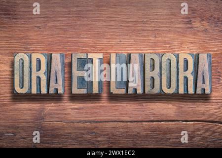 Ora et labora ancienne phrase latine signifiant prier et travailler, combinée sur une surface en bois verni vintage Banque D'Images