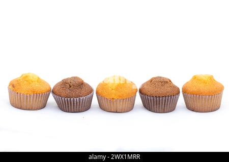 Cupcakes de couleur différente dans une rangée sur fond blanc Banque D'Images