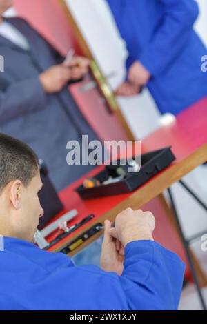 jeune bricoleur vissant le nouveau mécanisme de serrure de porte dans la porte Banque D'Images