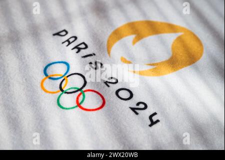 PARIS, FRANCE, 26 MARS 2024 : le logo officiel des Jeux olympiques d'été de Paris 2024 en lumière chaude sur serviette blanche Banque D'Images