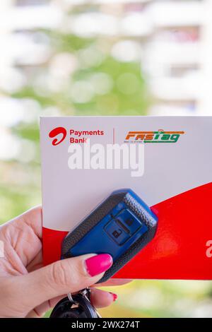 Femme tenant Airtel Payment Bank Fastag avec la clé de voiture montrant la nouvelle méthode de paiement de NHAI autorité routière nationale de l'Inde pour Toll Banque D'Images