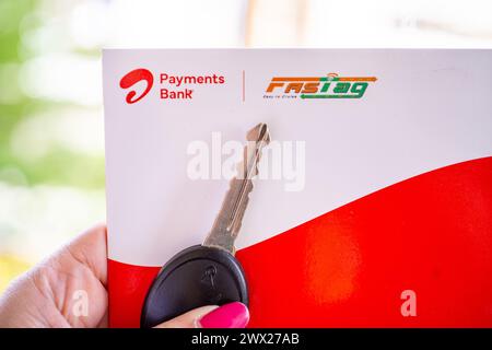 Femme tenant Airtel Payment Bank Fastag avec la clé de voiture montrant la nouvelle méthode de paiement de NHAI autorité routière nationale de l'Inde pour Toll Banque D'Images