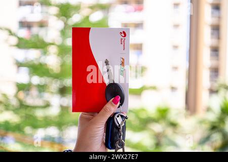 Femme tenant Airtel Payment Bank Fastag avec la clé de voiture montrant la nouvelle méthode de paiement de NHAI autorité routière nationale de l'Inde pour Toll Banque D'Images