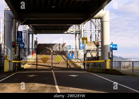 Une route menant à une rampe de chargement de ferry vide par une journée ensoleillée Banque D'Images