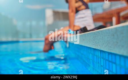 Jambes de femme méconnaissables pendant la journée d'été dans une piscine. Banque D'Images