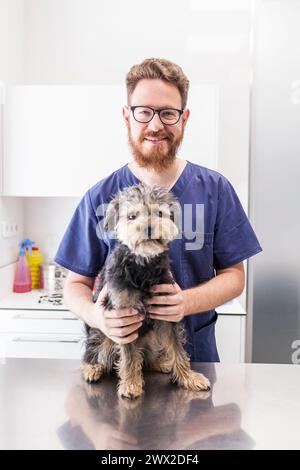 Vétérinaire masculin posant avec son chiot patient Banque D'Images