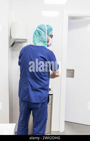 vétérinaire homme chirurgien dans les vêtements épi se préparant à opérer le lavage des mains dans l'évier de la clinique Banque D'Images