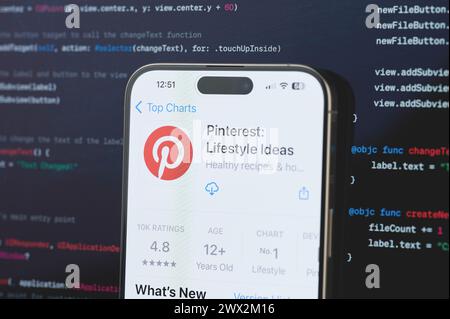 New York, USA - 23 février 2024 : Pinterest sur l'écran de l'iphone en arrière-plan de programmation de code flou Banque D'Images