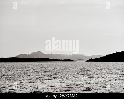 Les montagnes lointaines de l'île de Skye et le pont routier Skye Bridge au-dessus du Loch Alsh, Écosse, Royaume-Uni - B/W Banque D'Images